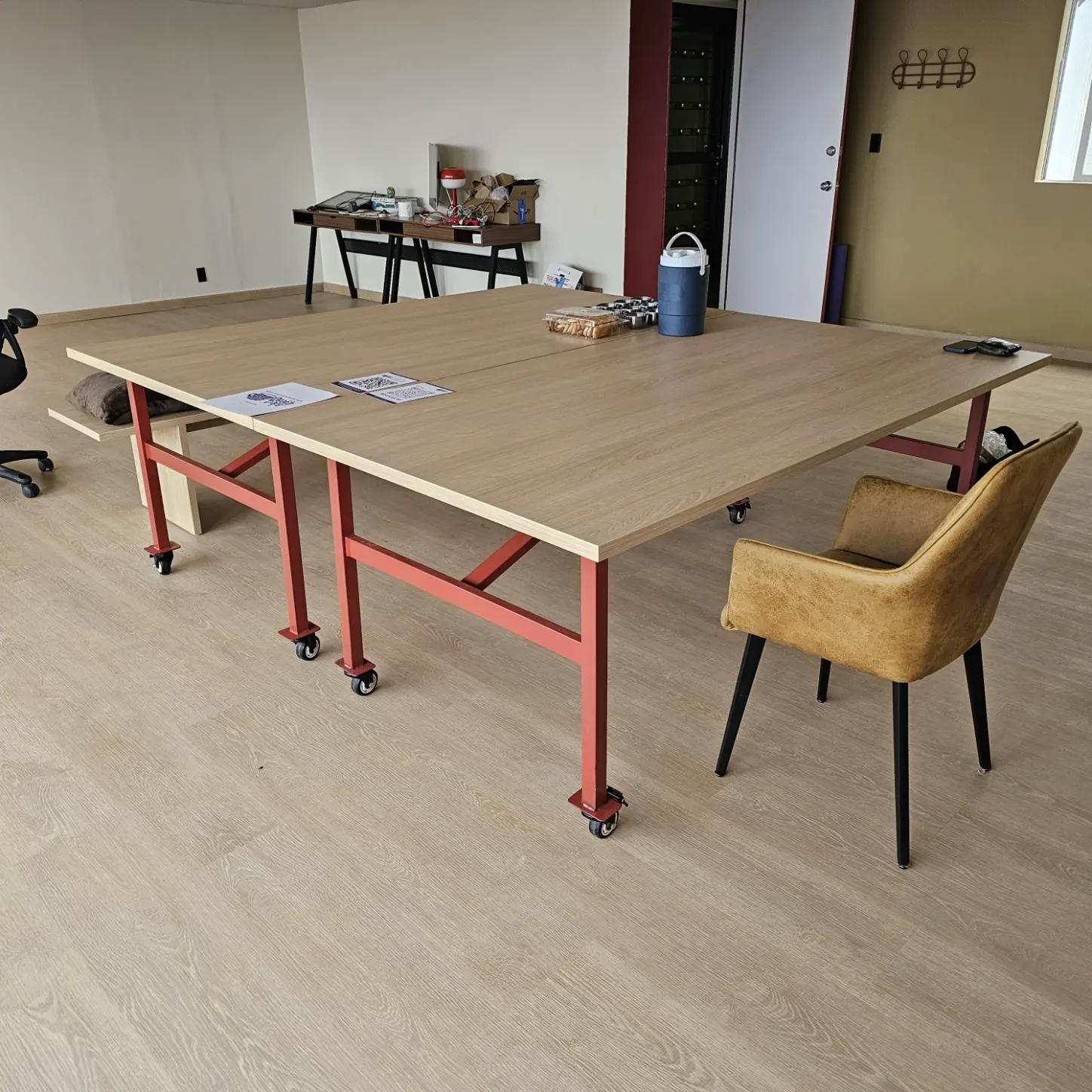 Mesa de sala de juntas con cubierta de madera, base metálica y ruedas