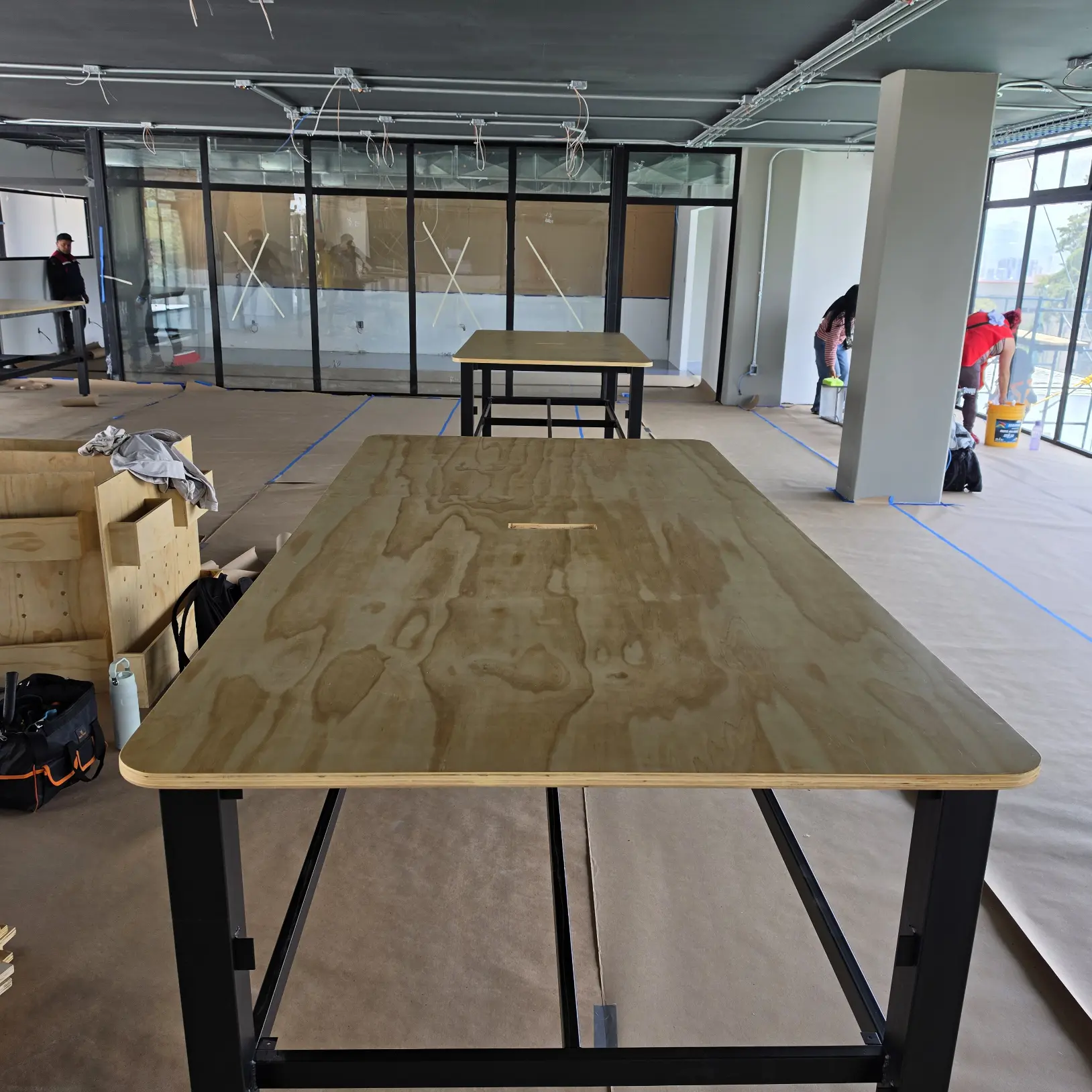 Mesa de trabajo en madera contrachapada con base metálica negra