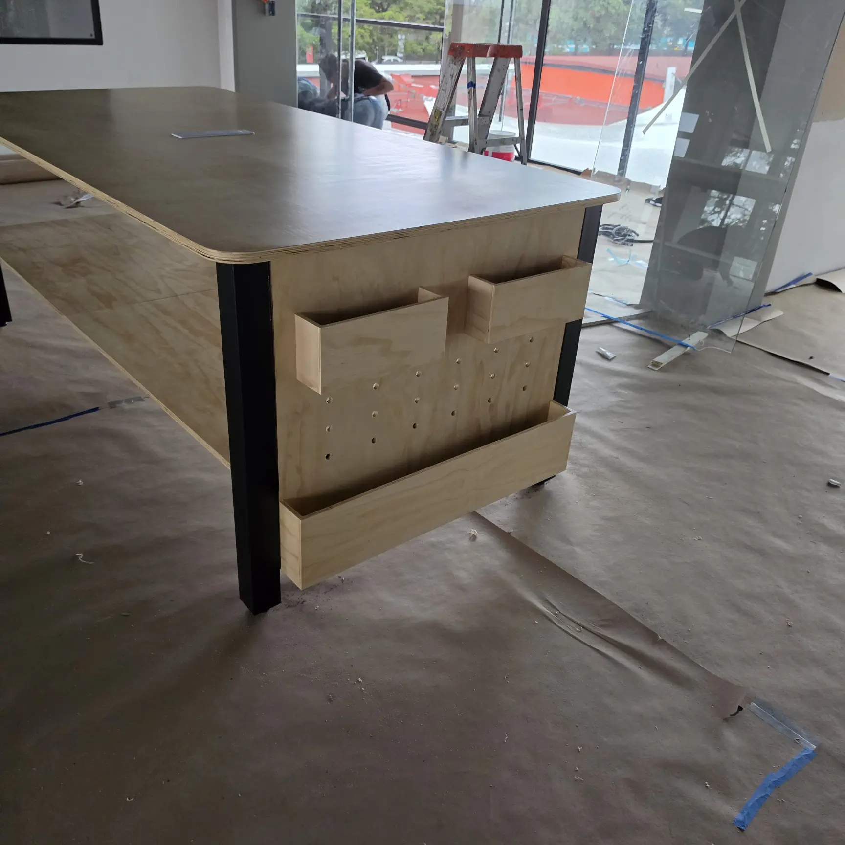 Detalle de mesa modular a medida con compartimentos integrados en madera