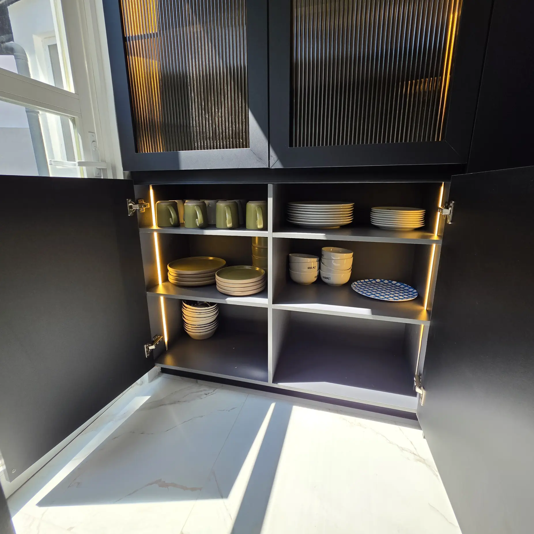Alacena de cocina integral en negro con puertas de vidrio canelado e iluminación LED