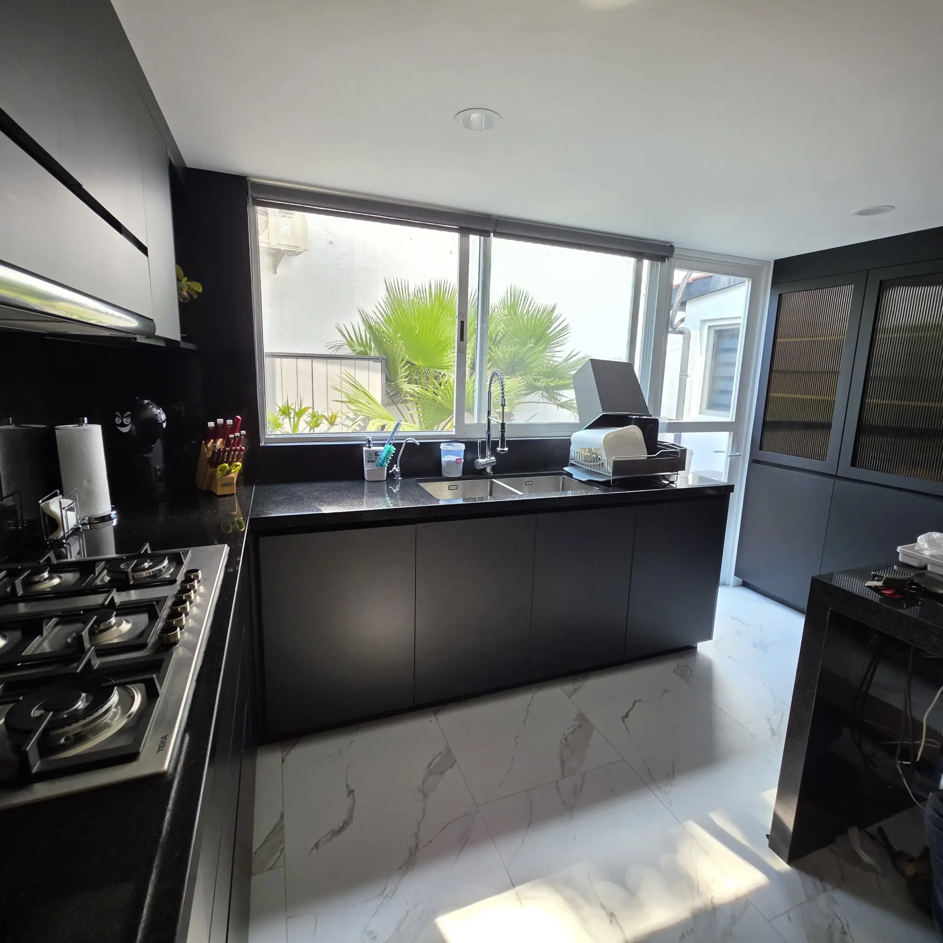 Cocina integral en negro con cubierta de granito y electrodomésticos empotrados